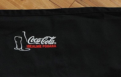 Haft komputerowy użyty do nadruku logo Coca-Cola na fartuchu