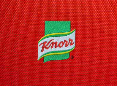 Logo firmy Knorr na czerwonym tle wykonane przy użyciu haftu komputerowego